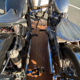 Two custom motorcycles secured side-by-side on a wooden trailer deck, photographed from a high-angle perspective.