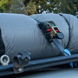 Retractable Tie Down Strap on a vehicle, with trees in the background